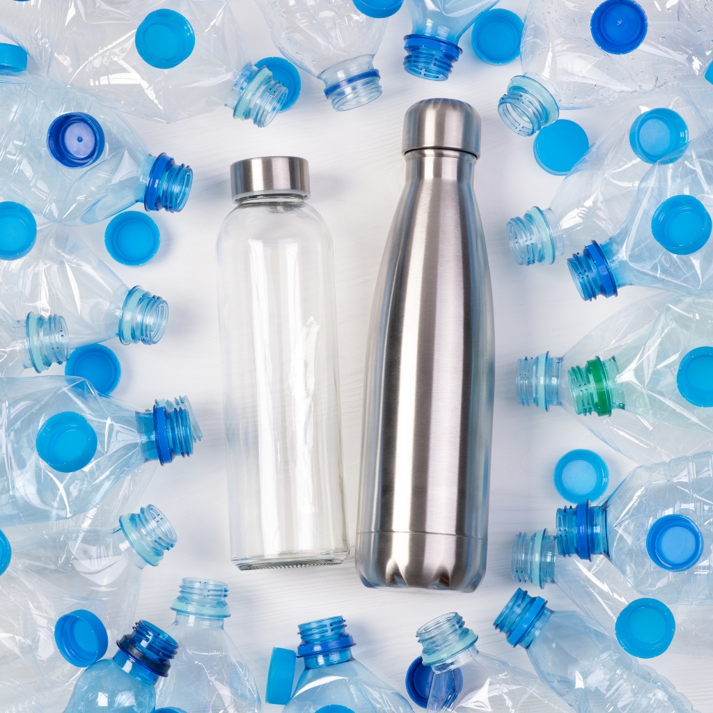 glass and metal bottle surrounded by plastic bottles