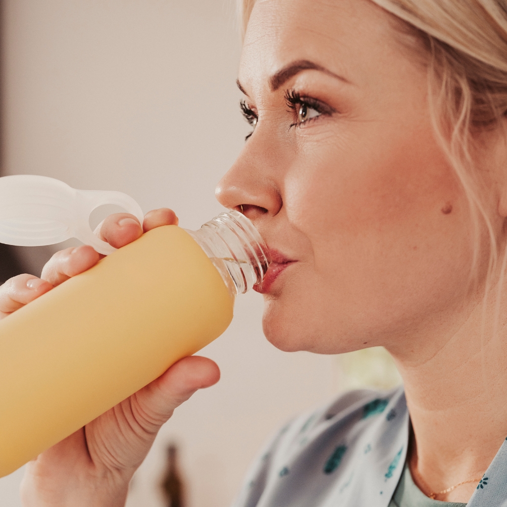 woman drinking out of water bottle